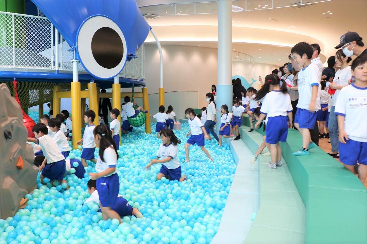 水色の沢山のボールが入ったボールプールに子供たちが入って遊んでいる写真