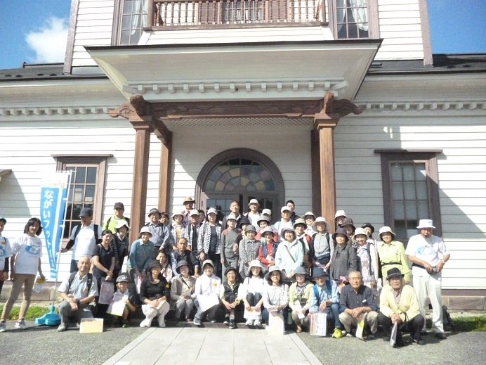 白い外壁で擬洋風建築2階建ての小桜館前に参加者の方々が集まって写っている集合写真