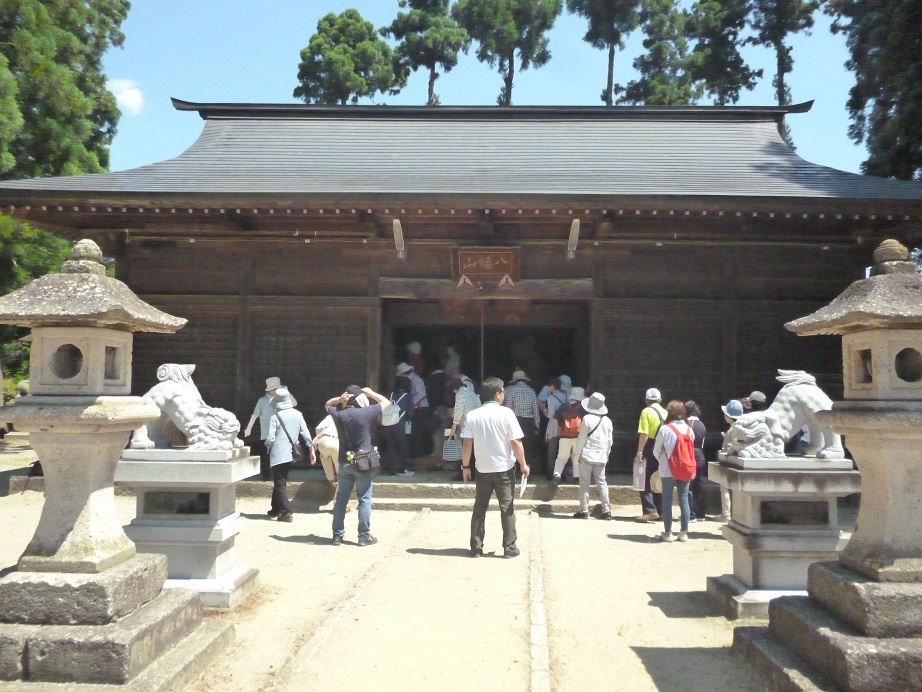 成田八幡神社前には石灯篭や狛犬があり、参加者の方々が成田八幡神社の屋内に入り見学している様子を写した写真