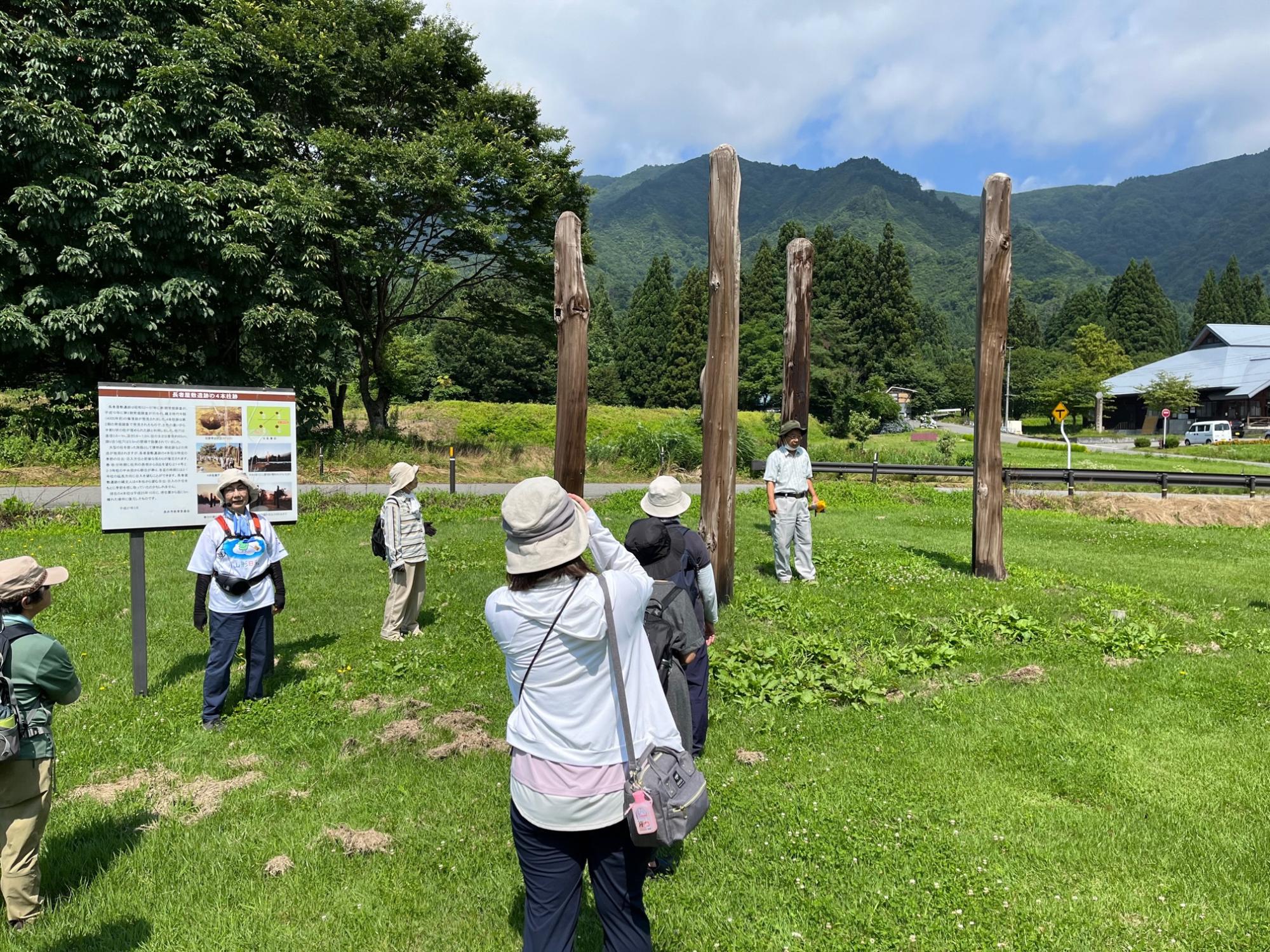 広々とした場所に四本の柱が四角形の四隅に立っており、参加者の方々が四本柱の周りや中央に立ち見学している様子の写真